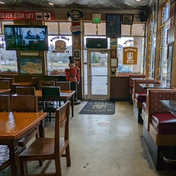 Interior of Wasatch Bagel and Grill with tables, booths, a TV, and a nutcracker near the entrance.