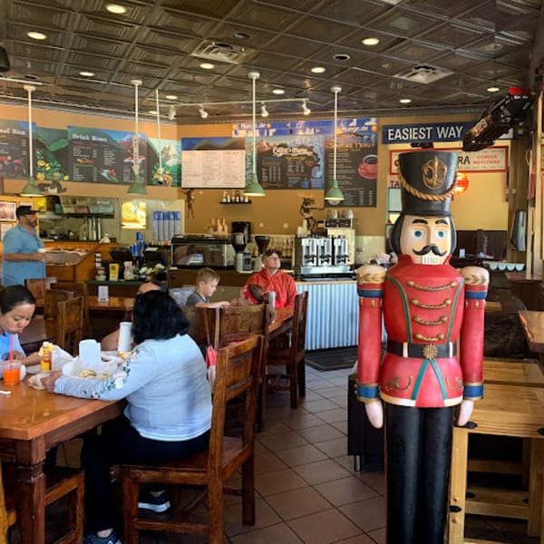 Interior of Wasatch Bagel and Grill with customers dining and a large nutcracker decoration.